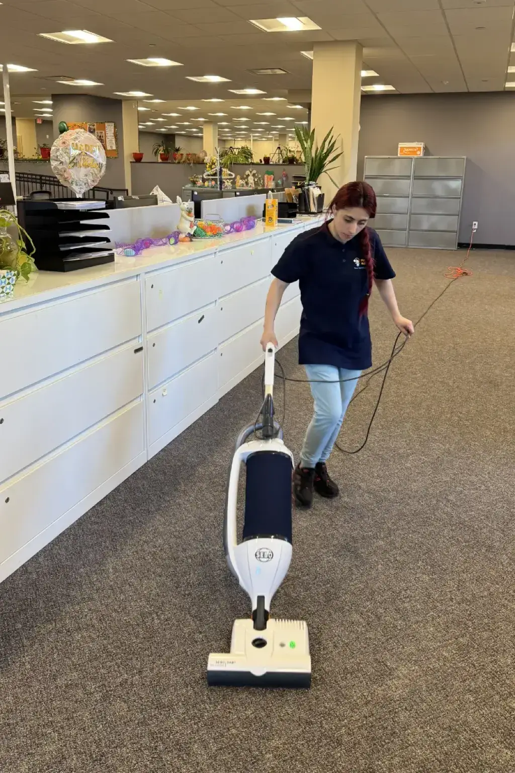 Fresca Cleaners team member vacuuming a commercial office space