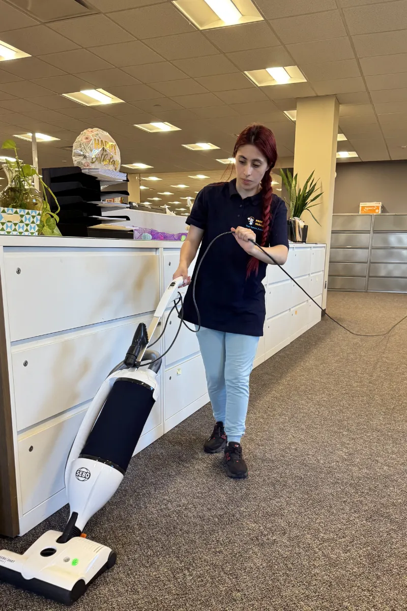 Limpiador comercial aspirando espacio de oficina